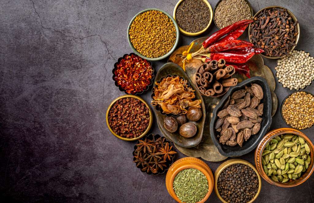 A top view of various Indian spices and seasonings on a table